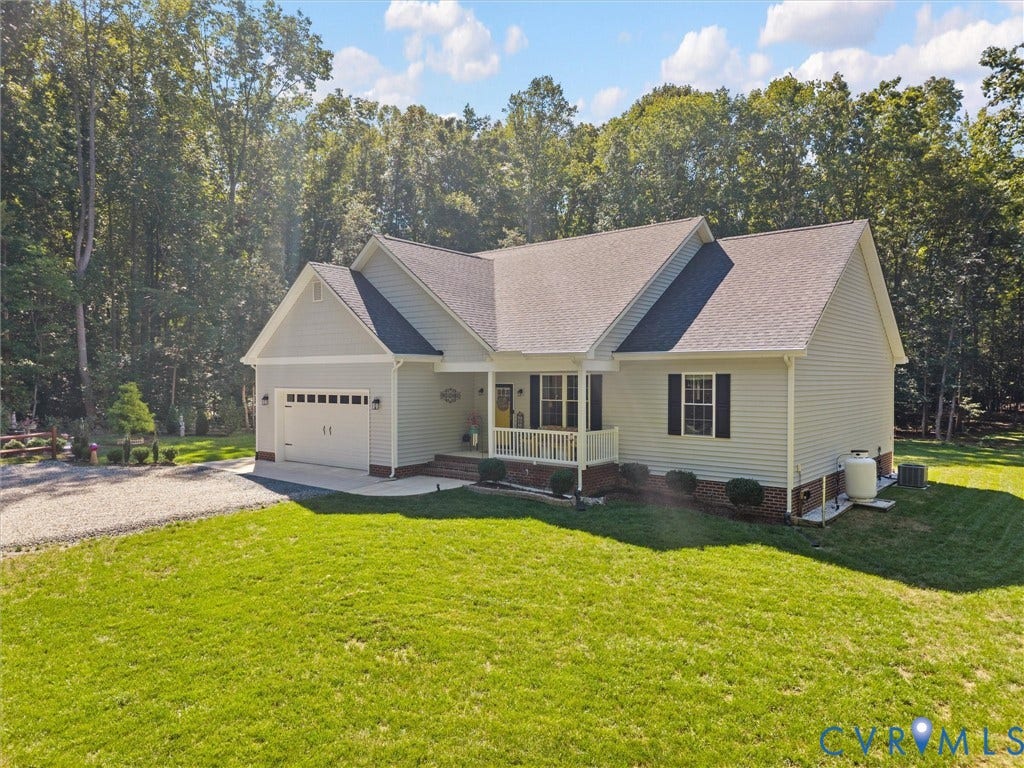 5927 Trenholm Village Drive, Trenholm Village, Powhatan, VA 23139 Light-colored siding exterior, attached two-car garage, covered front porch, gravel driveway, and surrounding green lawn