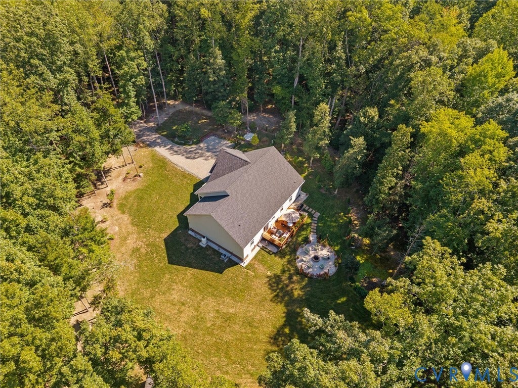 5927 Trenholm Village Drive, Trenholm Village, Powhatan, VA 23139 Expansive wooded property featuring a residential structure with a shingle roof, a gravel driveway, a wood deck, a stone patio, and a built-in fire pit