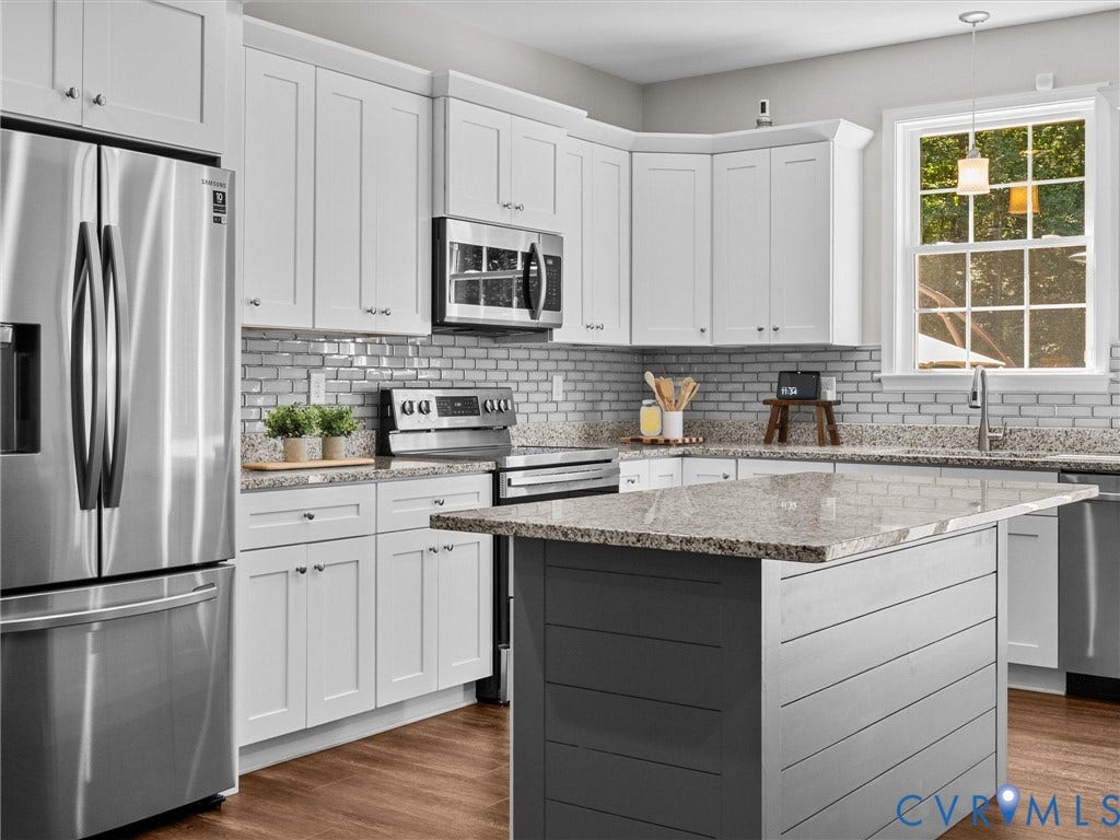 5927 Trenholm Village Drive, Trenholm Village, Powhatan, VA 23139 White shaker-style cabinetry, stainless steel appliances, light-toned granite countertops, a subway tile backsplash, and wood-finish flooring