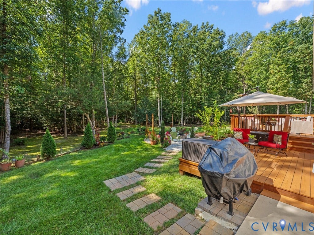 5927 Trenholm Village Drive, Trenholm Village, Powhatan, VA 23139 Expansive backyard featuring a manicured lawn, stone paver pathway, and a multi-level wood-finish deck