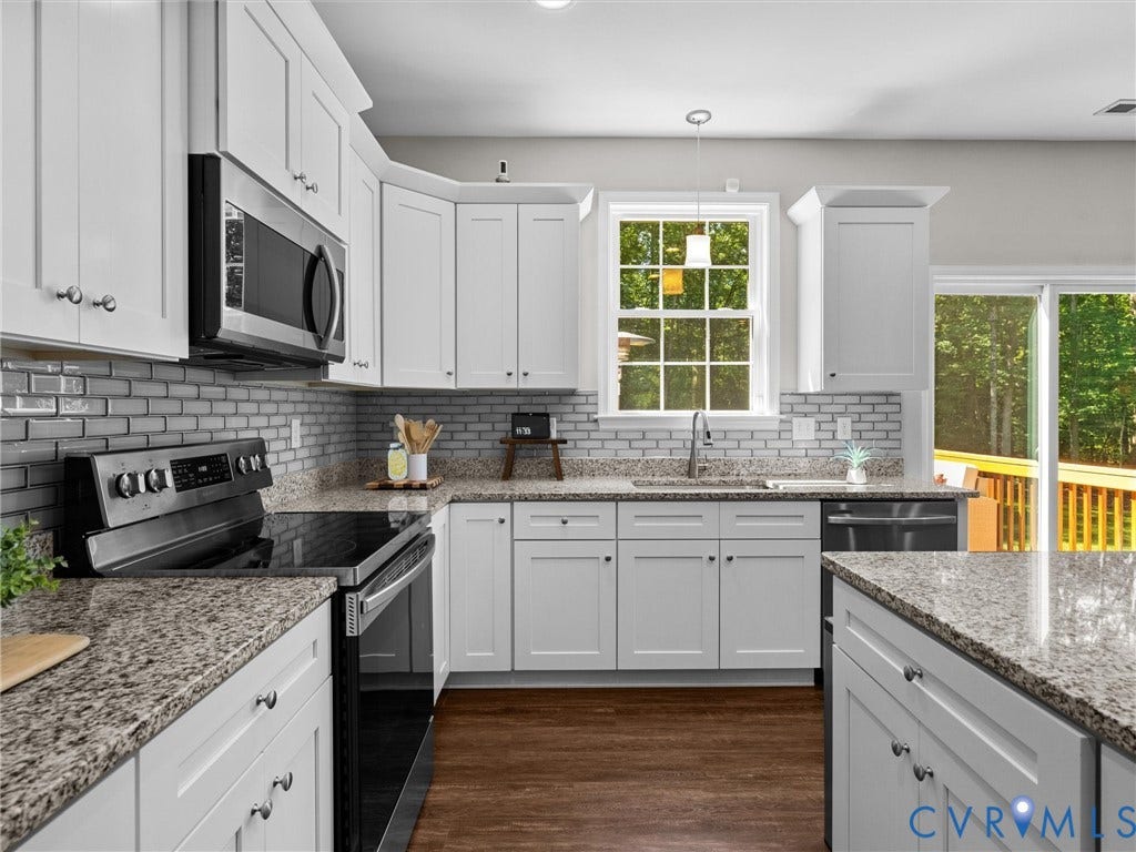 5927 Trenholm Village Drive, Trenholm Village, Powhatan, VA 23139 White cabinetry, granite countertops, subway tile backsplash, stainless steel appliances, and wood-finish flooring