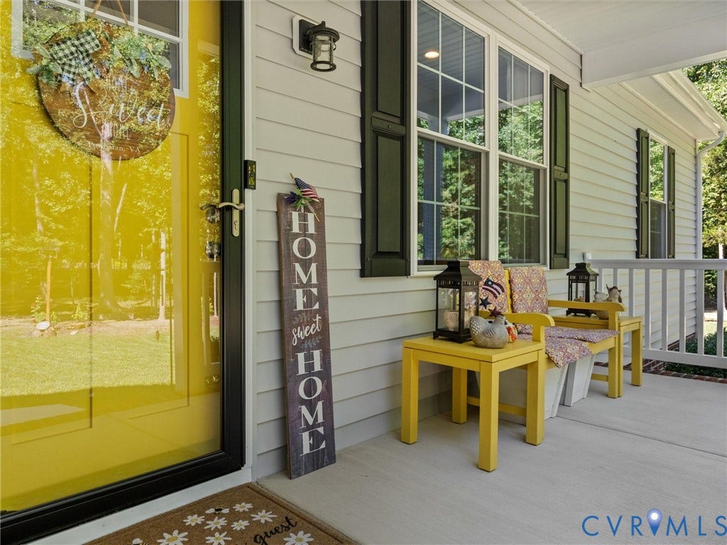 5927 Trenholm Village Drive, Trenholm Village, Powhatan, VA 23139 Front entrance featuring a bright yellow door, white siding, dark shutters, an exterior wall light, and a white porch railing