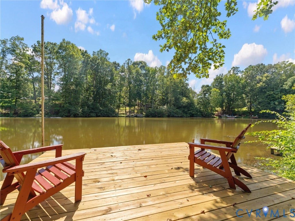 2135 Lakeview Drive, Lake Shawnee, Powhatan, VA 23139 Expansive waterfront deck with natural wood planks, featuring a serene lake and lush tree-lined surroundings