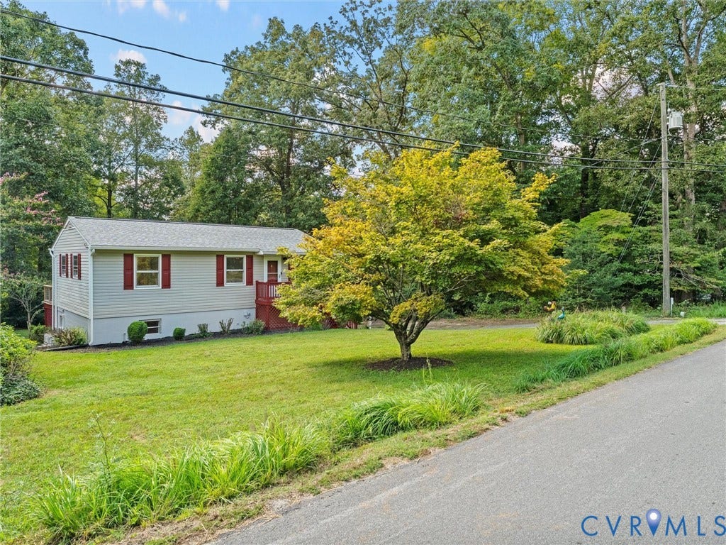 2135 Lakeview Drive, Lake Shawnee, Powhatan, VA 23139 Neutral siding exterior with red shutters and red porch railing, set against a backdrop of mature trees