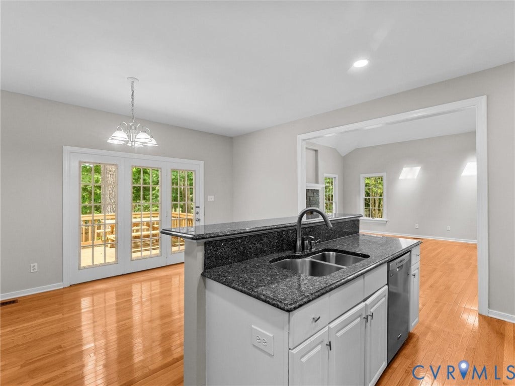 3700 Bremerton Drive, Wellesley, Henrico, VA 23233 Kitchen island featuring a dual-basin stainless steel sink with a high-arc faucet, integrated dishwasher, and granite-finish countertops