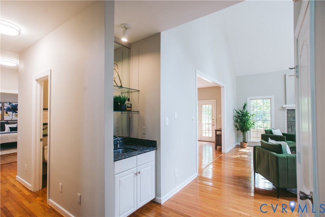3700 Bremerton Drive, Wellesley, Henrico, VA 23233 Hardwood flooring throughout, a vaulted ceiling, and a built-in wet bar with a granite-style countertop and glass shelving