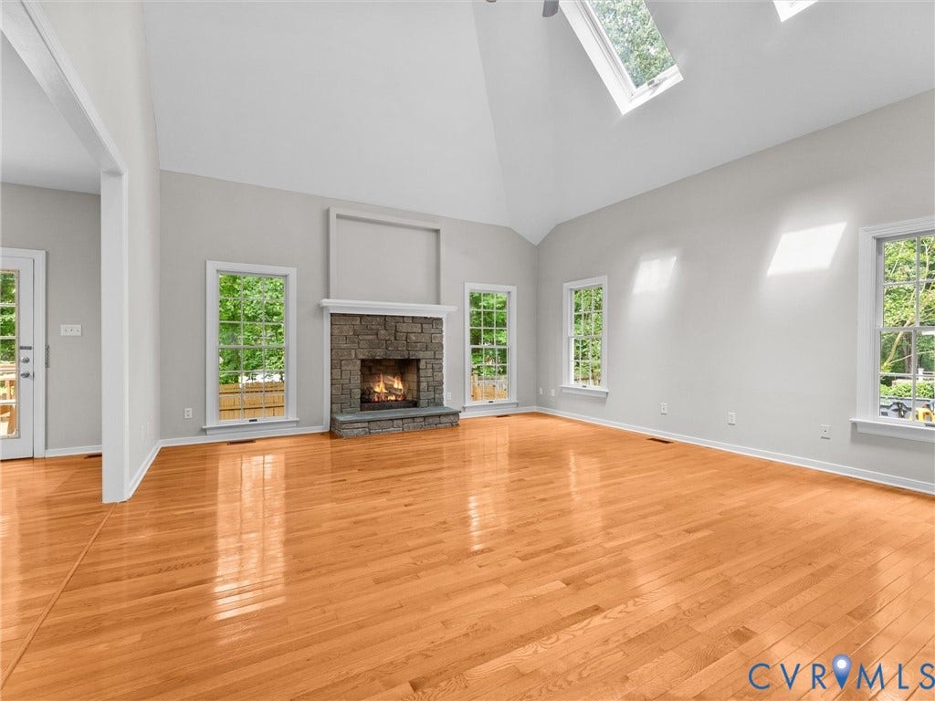 3700 Bremerton Drive, Wellesley, Henrico, VA 23233 Vaulted ceiling with skylights, stone fireplace, wood-finish flooring, and multiple windows