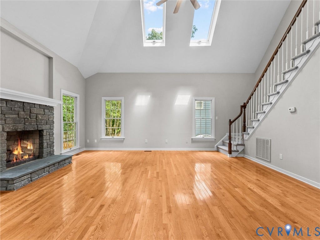 3700 Bremerton Drive, Wellesley, Henrico, VA 23233 Vaulted ceilings with skylights, stone-faced fireplace with hearth, hardwood flooring, and a staircase with wood handrails