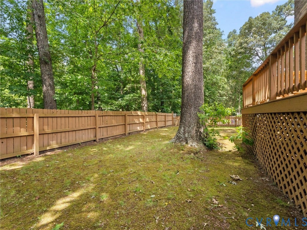 3700 Bremerton Drive, Wellesley, Henrico, VA 23233 Private fenced yard with mature trees and wood deck featuring lattice skirting