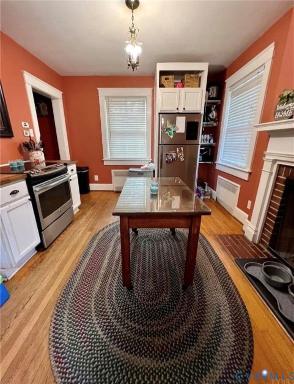 13232 W James Anderson Highway, Courthouse Area, Buckingham, VA 23921 Hardwood flooring, stainless steel appliances, built-in cabinetry, and a fireplace with a brick surround
