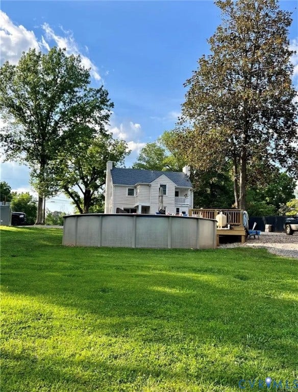 13232 W James Anderson Highway, Courthouse Area, Buckingham, VA 23921 Expansive green lawn featuring a large above-ground pool, a wooden deck, and mature trees