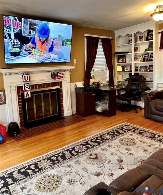 13232 W James Anderson Highway, Courthouse Area, Buckingham, VA 23921 Hardwood flooring, built-in shelving, white trim, and a fireplace with a brick hearth