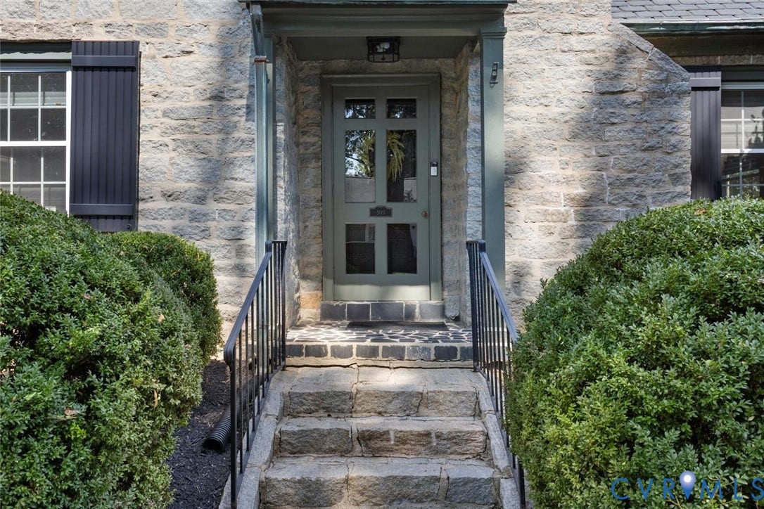 5113 King William Road, Westover Hills, Richmond, VA 23225 Stone facade with a paneled entry door, black wrought iron railings, and stone steps leading to the entrance