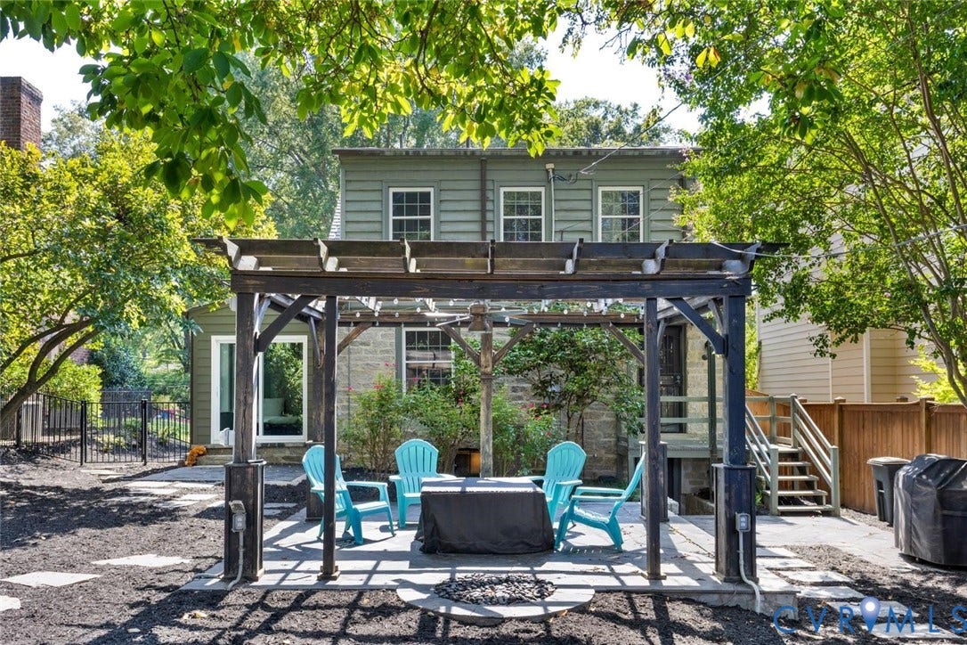 5113 King William Road, Westover Hills, Richmond, VA 23225 Backyard featuring a wood pergola over a stone patio, a stone house exterior, and a secondary structure with green siding