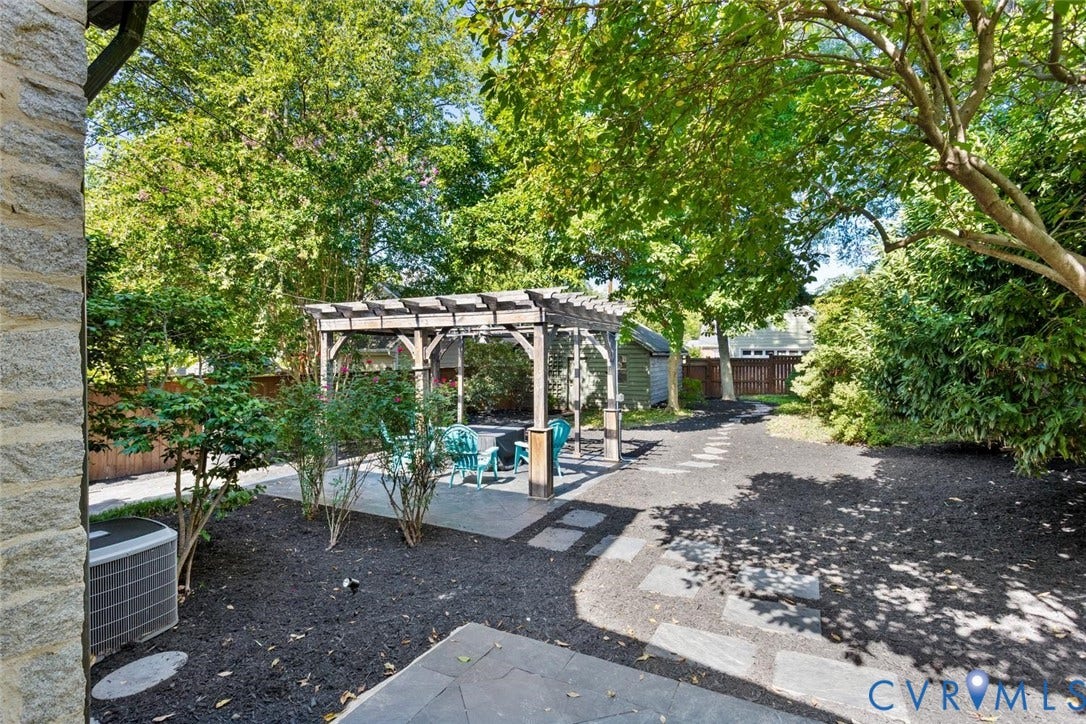 5113 King William Road, Westover Hills, Richmond, VA 23225 Expansive outdoor space featuring a wood pergola, stone-finish patio, stepping stone pathway, and mature trees
