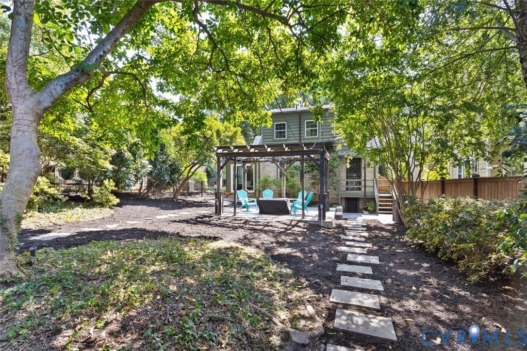5113 King William Road, Westover Hills, Richmond, VA 23225 Expansive backyard featuring mature trees, a stone paver path, a dedicated patio with a pergola, and a privacy fence