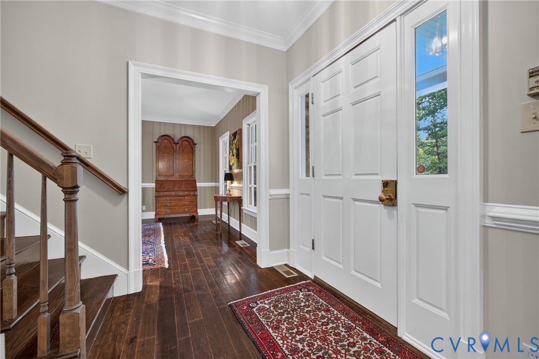 1108 Shallow Well Road, Manakin Sabot, VA 23103 Entryway featuring a paneled door with sidelights, dark wood-finish flooring, a wood-finish staircase, crown molding, and wainscoting
