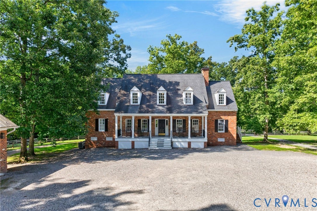 1108 Shallow Well Road, Manakin Sabot, VA 23103 Brick facade with white trim, a covered front porch, multiple dormer windows, and a gravel driveway