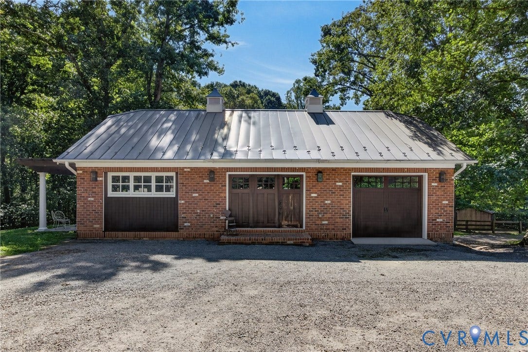 1108 Shallow Well Road, Manakin Sabot, VA 23103 Brick exterior with a metal roof, featuring a two-car garage, double entry doors, and a side pergola