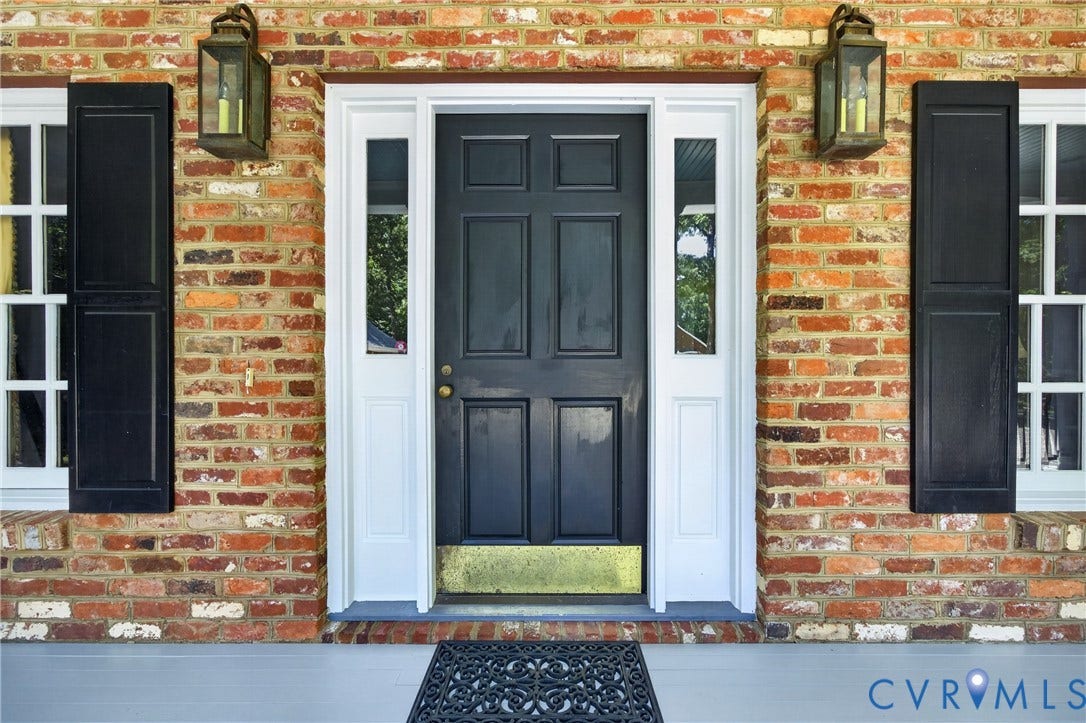 1108 Shallow Well Road, Manakin Sabot, VA 23103 Brick facade with a paneled front door, sidelights, and exterior lanterns