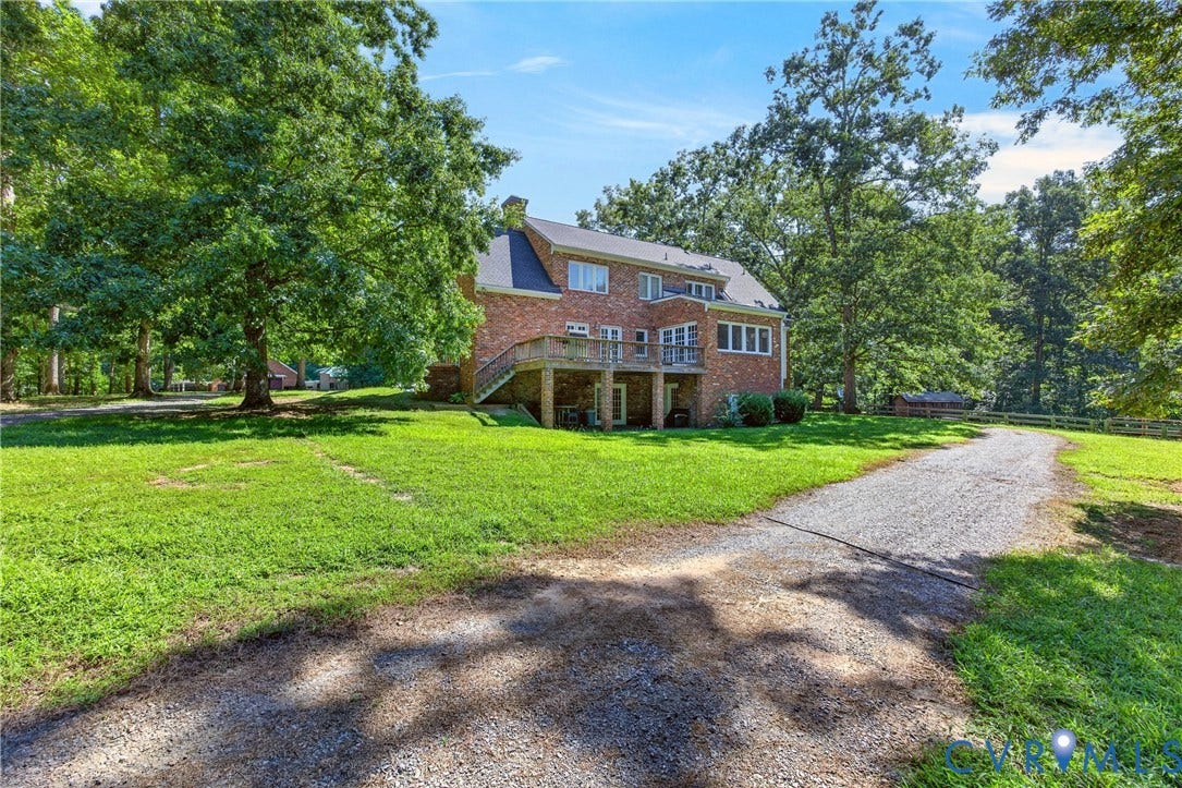 1108 Shallow Well Road, Manakin Sabot, VA 23103 Brick exterior with a multi-level deck, gravel driveway, and mature landscaping