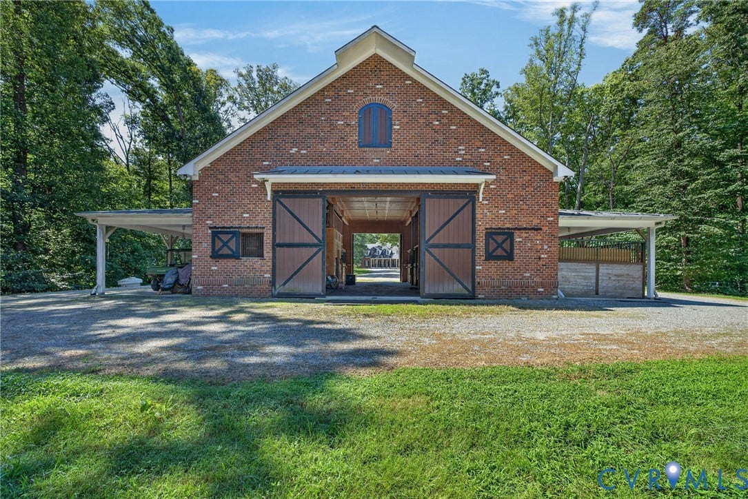 1108 Shallow Well Road, Manakin Sabot, VA 23103 Brick-clad stable structure featuring gabled roofline, arched window, and large sliding barn doors