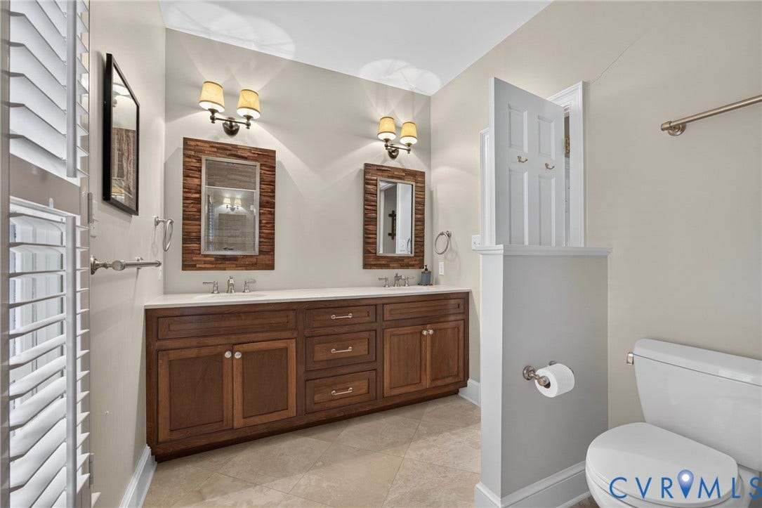 1108 Shallow Well Road, Manakin Sabot, VA 23103 Dual vanity with wood-finish cabinetry, integrated sinks, white countertops, and sconce lighting