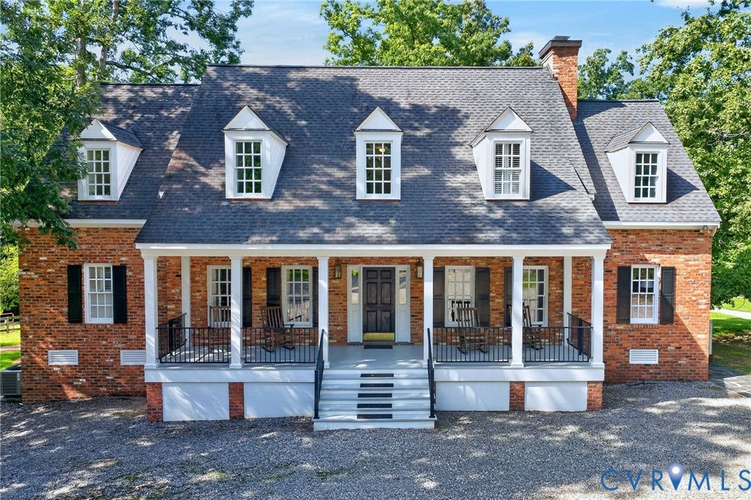 1108 Shallow Well Road, Manakin Sabot, VA 23103 Brick exterior with dormer windows, covered front porch, white columns, and dark shutters