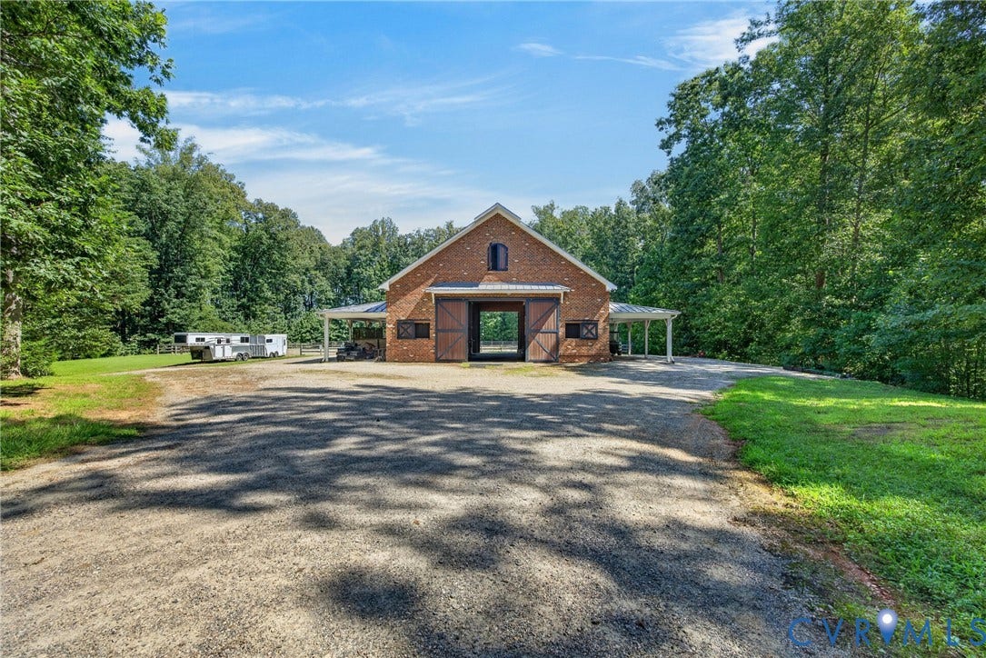 1108 Shallow Well Road, Manakin Sabot, VA 23103 Brick barn structure with large sliding doors, covered side porches, and a gravel driveway
