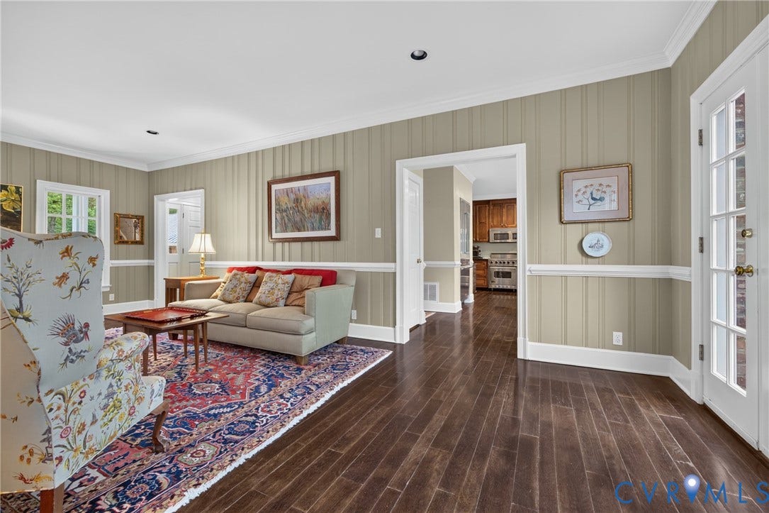 1108 Shallow Well Road, Manakin Sabot, VA 23103 Dark wood-finish flooring, paneled wall detailing, white crown molding, and a French door with glass panes