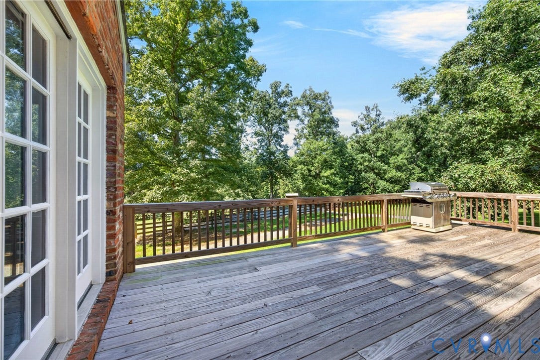 1108 Shallow Well Road, Manakin Sabot, VA 23103 Expansive wood deck with a perimeter railing, French doors, and mature trees in the background