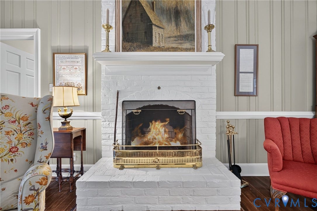 1108 Shallow Well Road, Manakin Sabot, VA 23103 Brick fireplace with a white painted finish, complete with a brass-detailed fire screen and iron tools