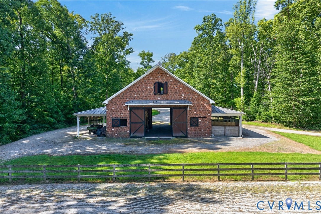 1108 Shallow Well Road, Manakin Sabot, VA 23103 Brick barn structure with a metal roof, featuring large sliding barn doors and an attached covered carport
