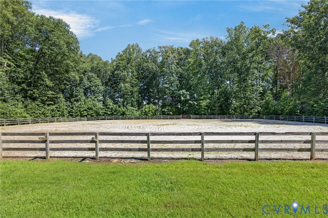 1108 Shallow Well Road, Manakin Sabot, VA 23103 Fenced equestrian arena with sand footing, bordered by mature trees and a grassy foreground