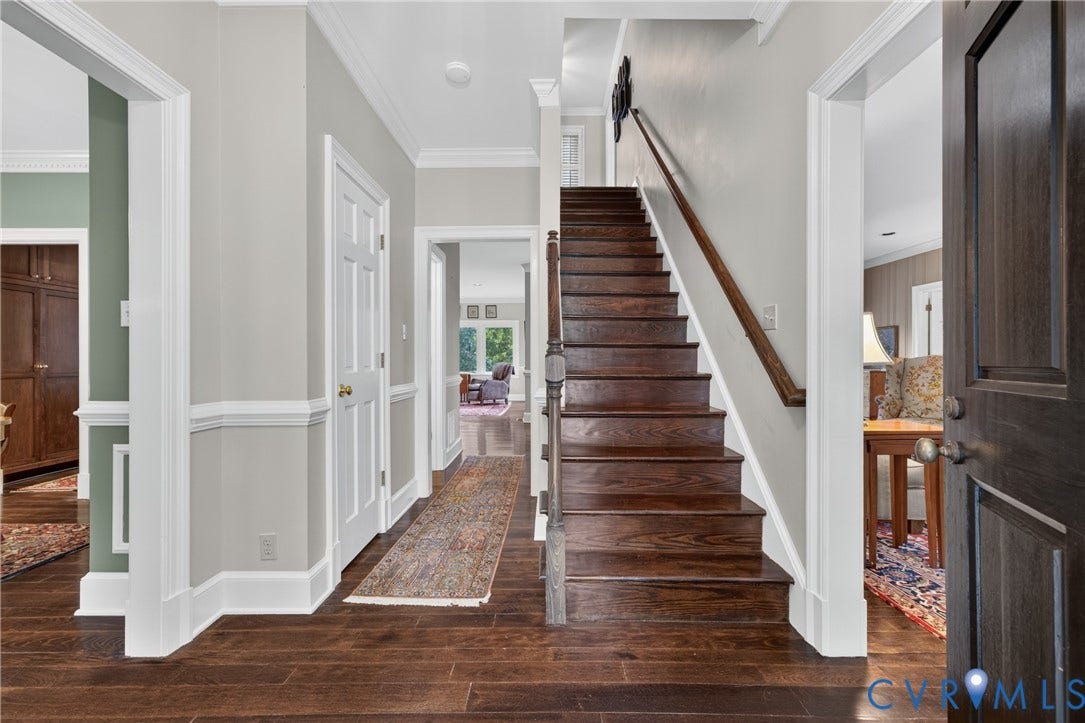 1108 Shallow Well Road, Manakin Sabot, VA 23103 Hardwood flooring, classic wood staircase, white trim details, panel doors, and a dark wood front door