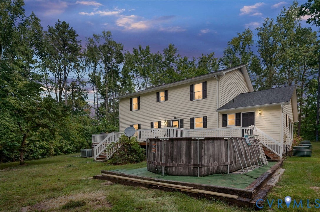Two-story exterior with light-colored siding, black shutters, and a dark-shingle roof