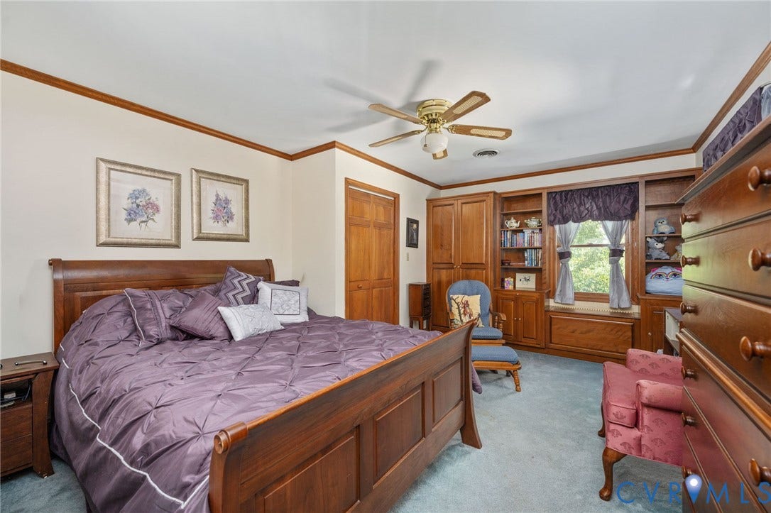 Built-in shelving and cabinetry, window seat, ceiling fan, wood-finish trim, and closet with wood-finish doors