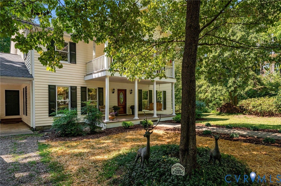 Two-story exterior with a covered porch, upper balcony, and contrasting shutters