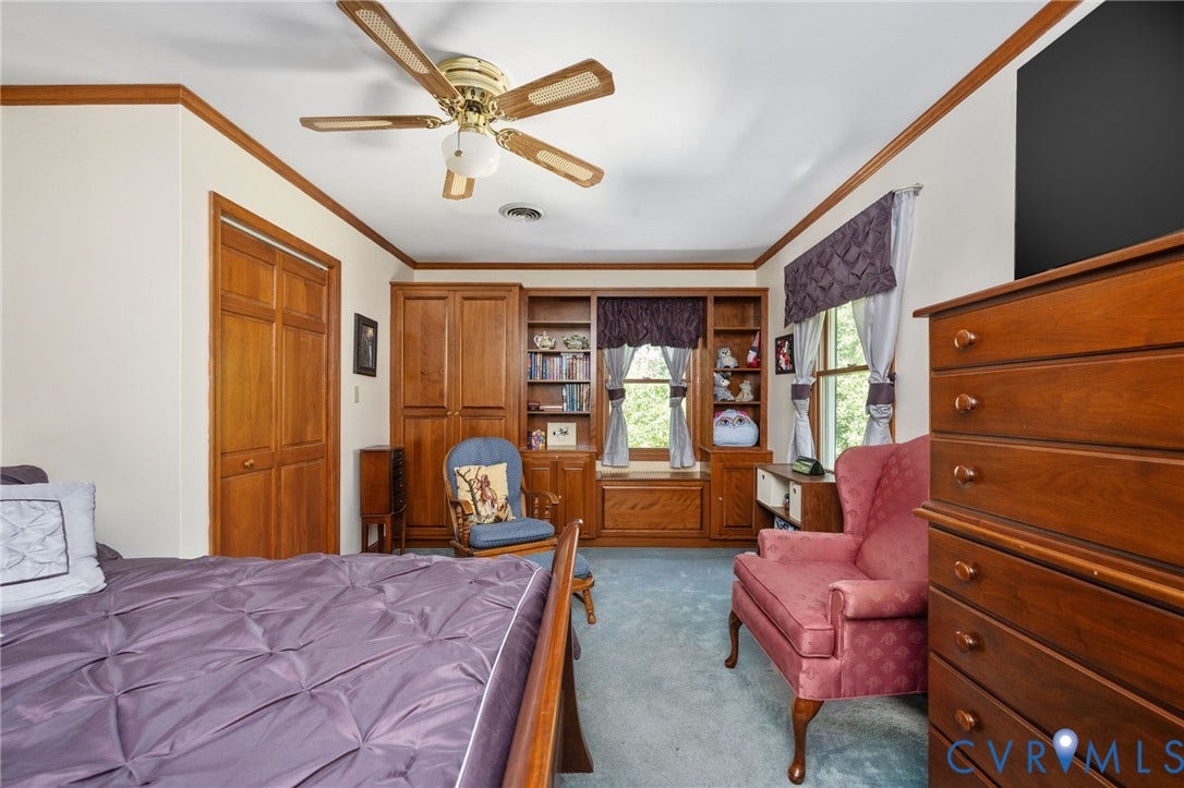 Built-in shelving, wood-paneled closet doors, and wood trim molding, complemented by a ceiling fan