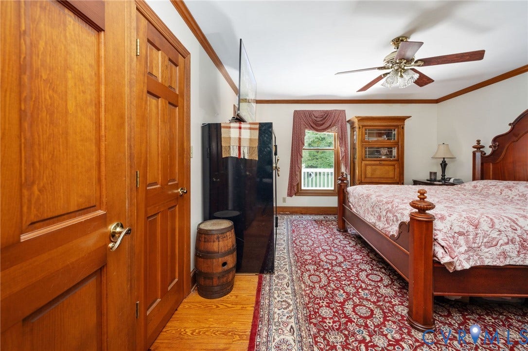 Hardwood flooring with wood-paneled doors, crown molding, and a ceiling fan with integrated lighting