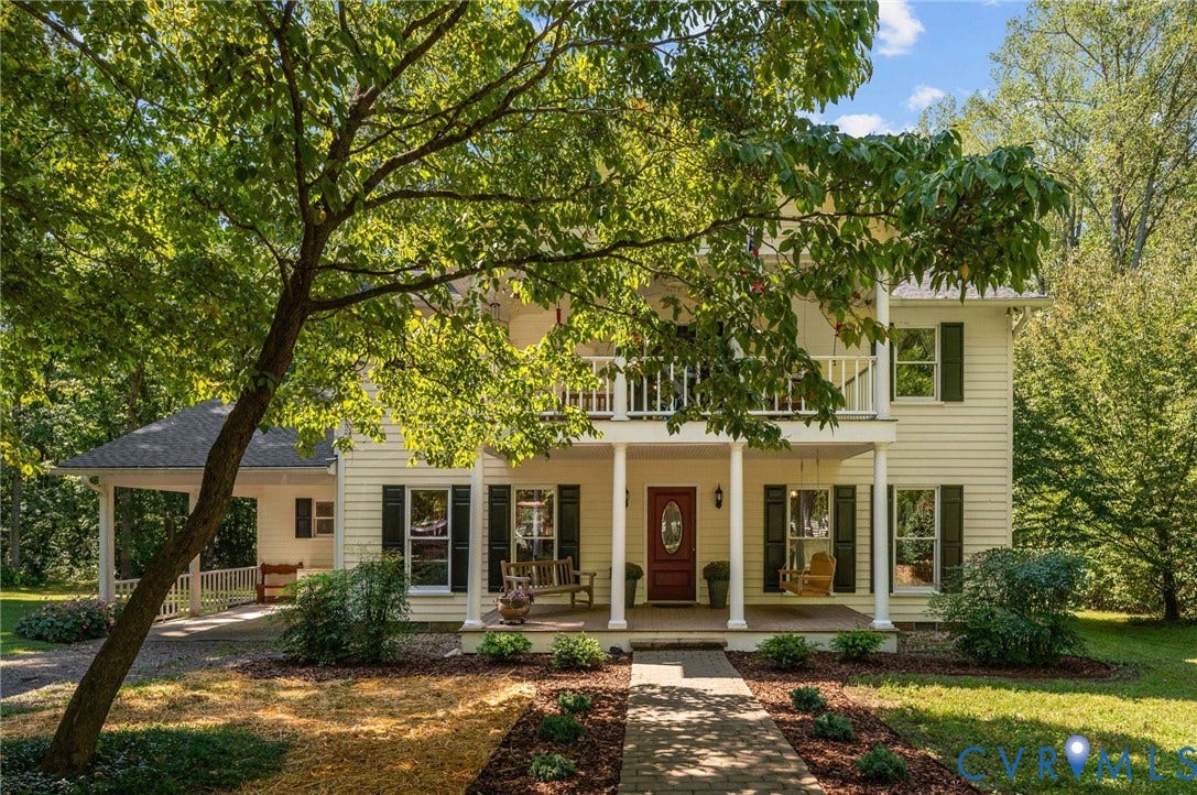 Two-story exterior with a covered porch, upper balcony, and attached covered carport