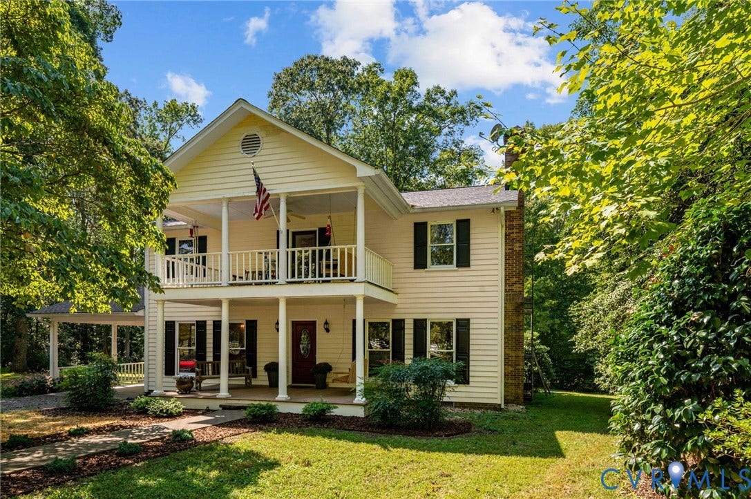 Two-story residence featuring a covered front porch and upper-level balcony