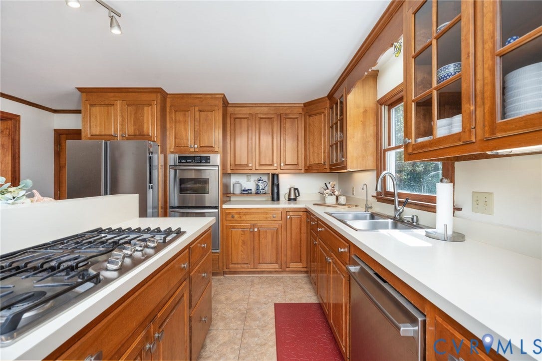 Kitchen featuring wood cabinetry, stainless steel appliances, white countertops, a built-in oven, and a gas range