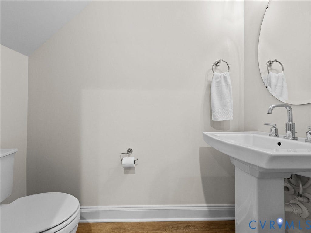 366 Souldren Walk, #A, Short Pump, Henrico, VA 23233 half bath on level 1. Pedestal sink with chrome fixtures, oval wall mirror, and wood-finish flooring