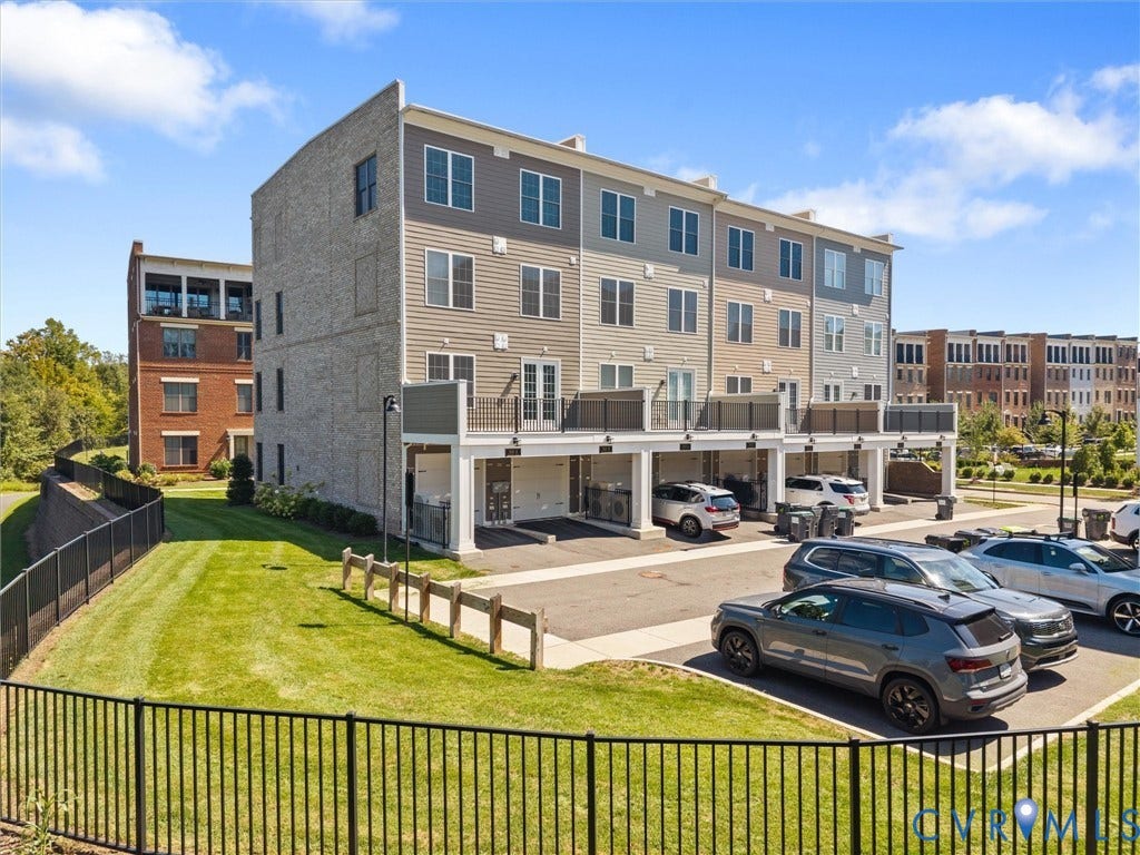 366 Souldren Walk, #A, Short Pump, Henrico, VA 23233 Multi-level residential building featuring brick and siding exterior, multiple balconies with metal railings, and covered parking spaces