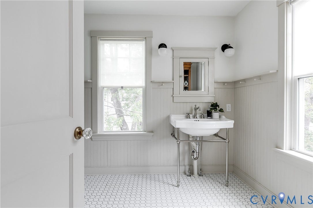 4015 Mount Vernon Street, Bellevue, Richmond, VA 23227 Pedestal sink with chrome-finish stand, integrated medicine cabinet with mirror, wall-mounted sconces, hexagonal floor tiling, and beadboard wainscoting