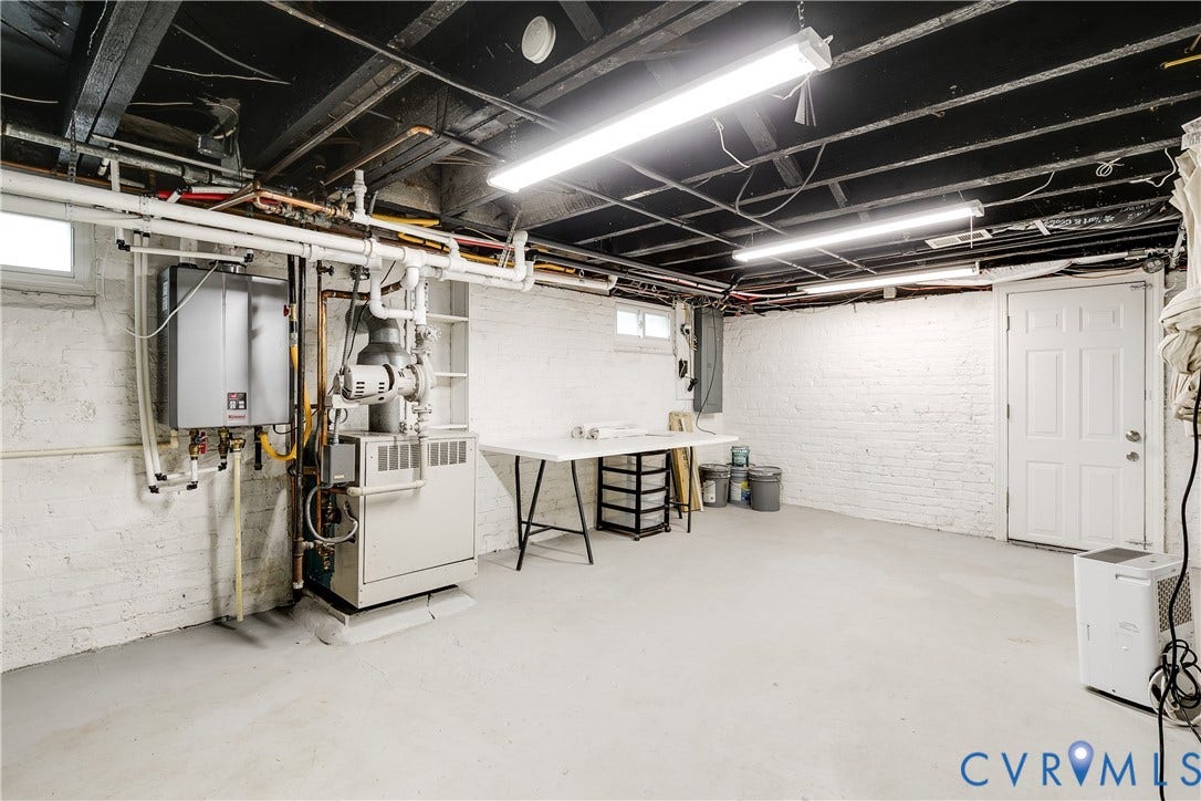 4015 Mount Vernon Street, Bellevue, Richmond, VA 23227 Spacious utility area featuring painted brick walls, exposed ceiling joists, and a solid core door