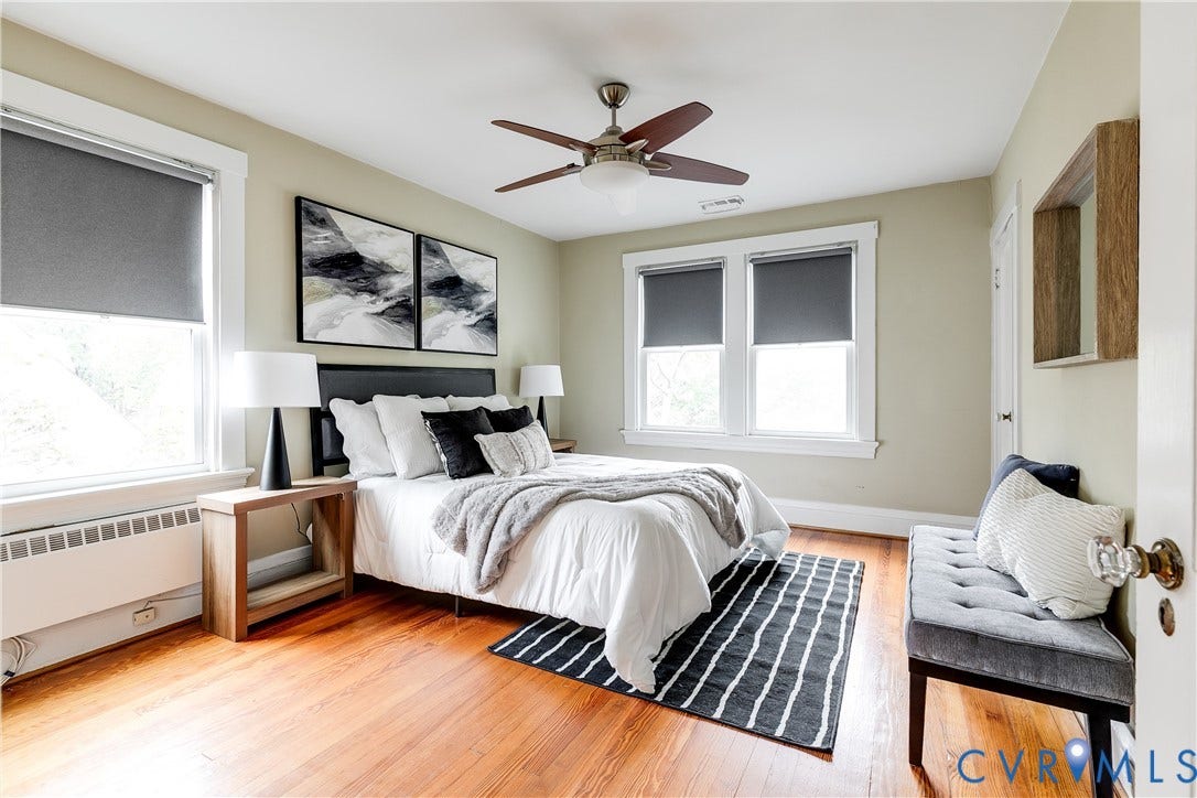 4015 Mount Vernon Street, Bellevue, Richmond, VA 23227 Hardwood flooring, painted walls, ceiling fan with light fixture, multiple windows with roller shades, and a built-in radiator