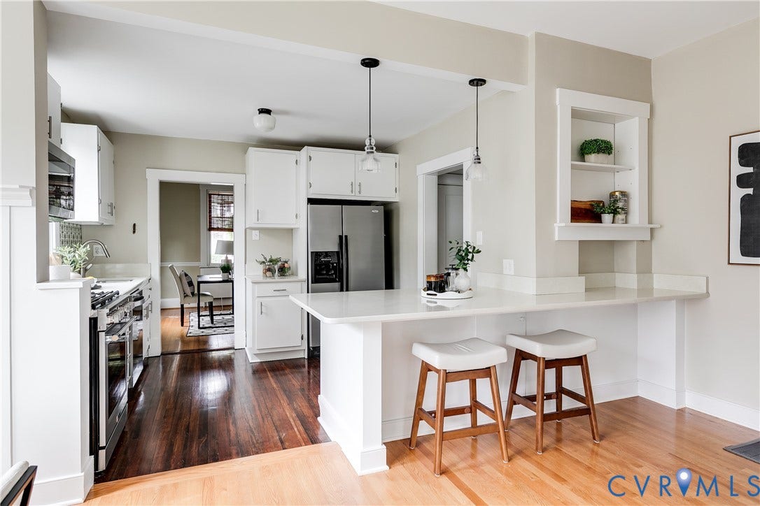 4015 Mount Vernon Street, Bellevue, Richmond, VA 23227 Kitchen featuring white cabinetry, stainless steel appliances, a white countertop island with seating, and pendant lighting