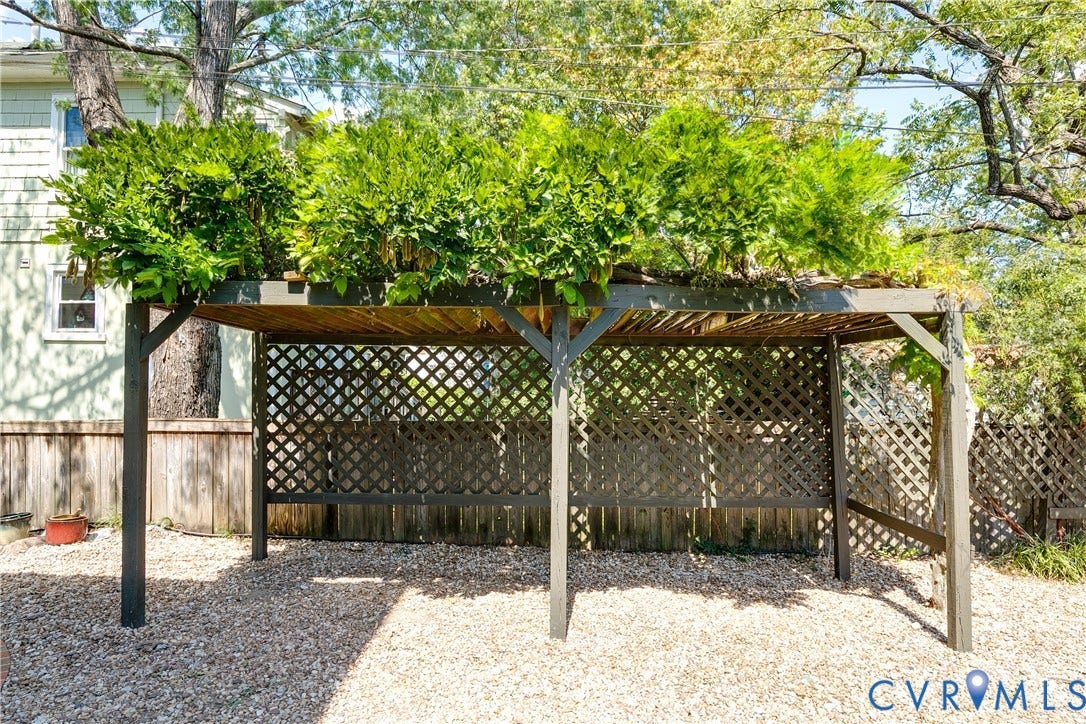 4015 Mount Vernon Street, Bellevue, Richmond, VA 23227 Pergola structure with lattice detailing, topped with lush greenery, set on a gravel surface